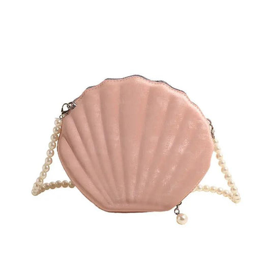 Pink seashell-shaped purse with pearl strap on white background